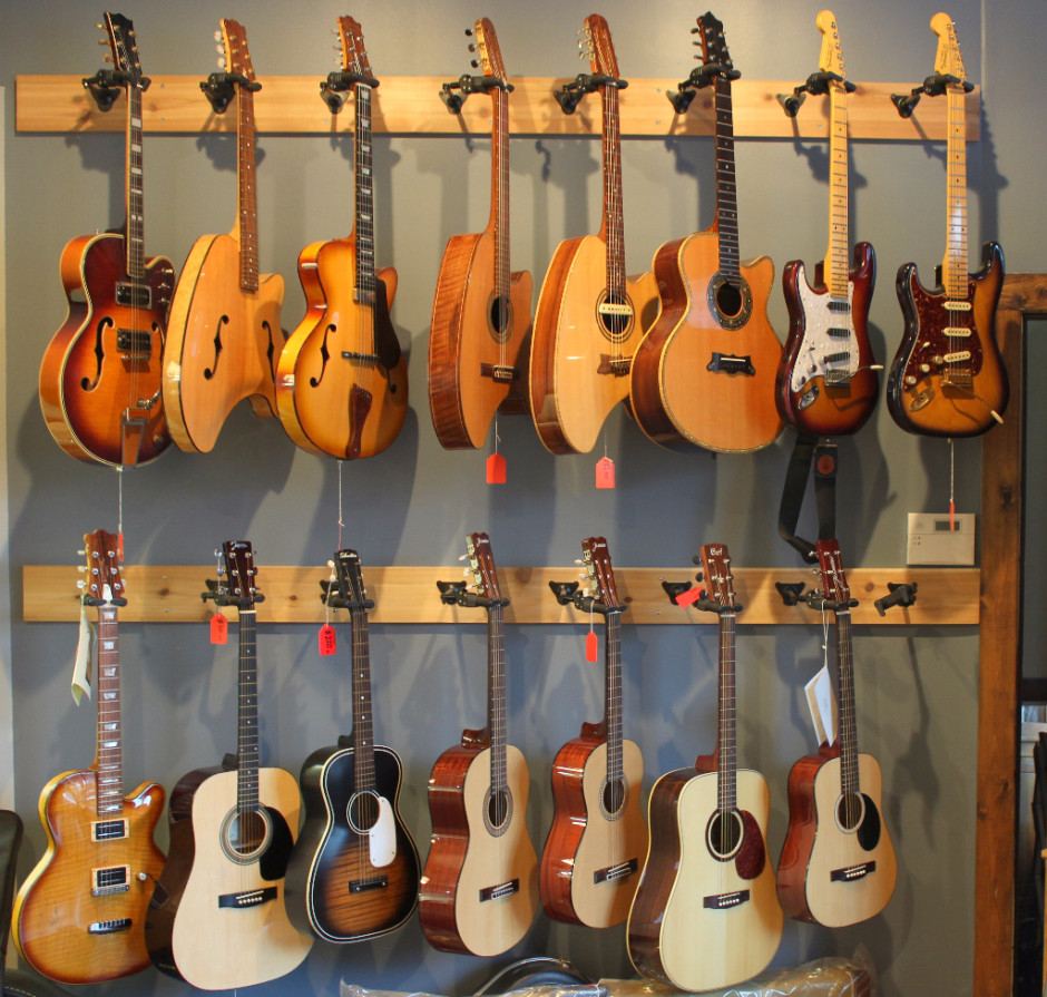 Wall of acoustic and electric guitars inside Danche Guitars