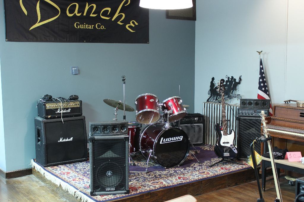 The shop's stage with drum kit and Marshall amps